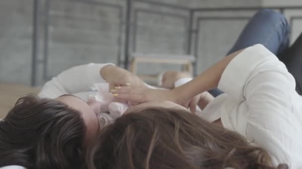 Overhead shot gelukkig paar liggend in het bed spelen met roze Childrens Pointe close-up. Jonge familie wachten op een meisje van de baby. Tender relatie concept, mensen in de liefde. Zijaanzicht — Stockvideo