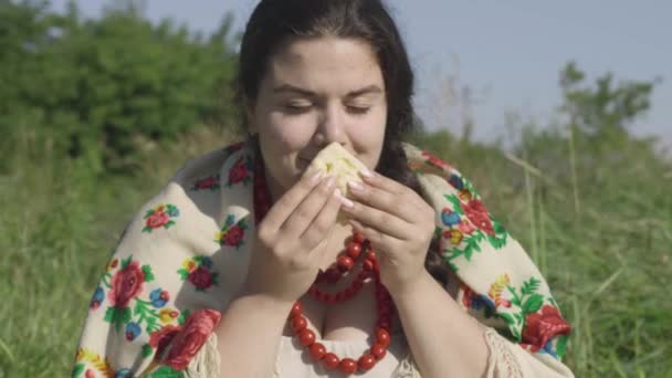 Retrato de una hermosa mujer con sobrepeso comiendo panqueques con queso cottage al aire libre. Comida casera saludable, conexión con la naturaleza. Estilo de vida rural. Almuerzo en el campo. Mujer rural real . — Vídeo de stock