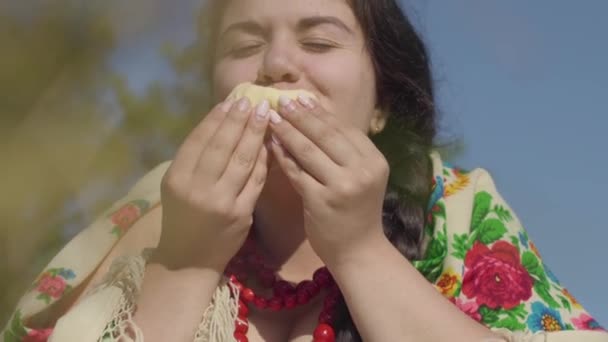 Portrait of beautiful overweight woman eating pancakes with cottage cheese outdoors. Healthy homemade food, connection with nature. Country lifestyle. Lunch break in the countryside. Real rural woman. — Stock Video
