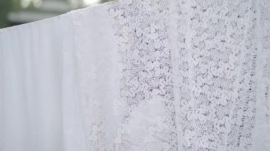 Uzun saçlı ve hasır sepet ile çekici olgun kadın elinde bir çamaşır ipi açık havada beyaz giysiler asılı ve kamera gülümseyerek bakıyor. Yıkanıyor. Çamaşır yıkıyorum bayan