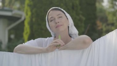 Portre sevimli yaşlı kadın kafasına şal yeşil biber yeme kamera çamaşır ipi açık havada gülümseyerek bakarak. Yıkanıyor. Güzel ev hanımı çamaşır yıkıyorum.