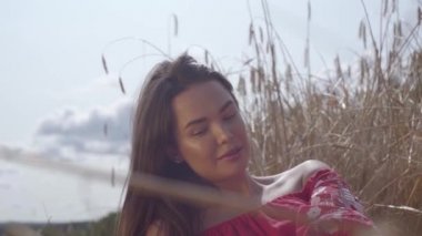 Genç sevinç kadın inanılmaz renkli güneş ışınları buğday alanında doğa ve güneş ışığı zevk. Sevimli kendine güvenen kız kameraya bakıyor. Gerçek insanlar serisi. Yavaş çekim.