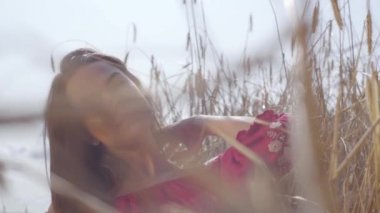 Genç sevinç kadın inanılmaz renkli güneş ışınları buğday alanında doğa ve güneş ışığı zevk. Sevimli kendine güvenen kız açık havada. Gerçek insanlar serisi. Yavaş çekim.