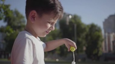 Güzel küçük çocuk sabun kabarcıkları üfleme portresi. Sevimli çocuk yalnız açık havada vakit geçiriyor. Yaz tatilinde. Sevimli çocuk parkta eğlenceli.