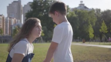 Yaşlı kız kardeşi yaz parkında küçük kardeşini azarlama. Kardeşler arasındaki ilişki. Yaramaz çocuk kız kardeşi açık havada yürüyüş.