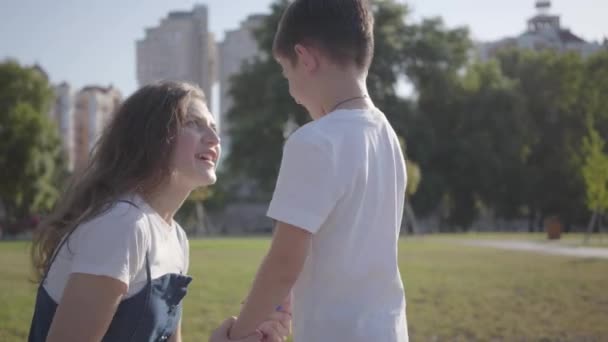 Relação entre os irmãos. Irmã mais velha repreendendo seu irmão mais novo no parque de verão. Menino safado andando com sua irmã ao ar livre . — Vídeo de Stock