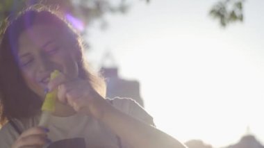 Kamerada sabun kabarcıkları üfleme parkta genç kızın portresi. Sevimli genç kadın açık havada yalnız vakit geçiriyor. Summertime Leisure