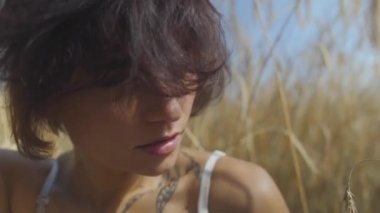 Buğday alanında kısa saçlı Sevimli kadının yakın yukarı portre. Kız doğaya sahiptir. Kendine güvenen kaygısız kız açık havada. Gerçek insanlar serisi.