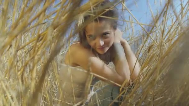 Urocza kobieta z krótkimi włosami na polu pszenicy. Dziewczyna cieszy się naturą patrząc i stwarzające w aparacie. Pewna beztrosko dziewczyna na zewnątrz. Seria prawdziwych ludzi — Wideo stockowe