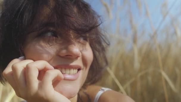 Close-up Portret vrouw met kort haar op het tarwe veld. Meisje geniet van de natuur. Zelfverzekerd zorgeloos meisje buitenshuis. Echte mensen serie. — Stockvideo