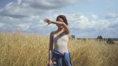 Bodysuit giyen emin kadın bir şey sunuyor ve havada bir elle reklamları gösterir. Sanal reklam kavramı. Sanal yazıt üzerinden ilerleyin. Carefree kız açık. Gerçek insanlar serisi