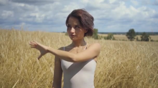 Шикарна жінка, одягнена в боді-костюм, представляє щось і показує рекламу рукою в повітрі. Концепція віртуальної реклами. Прокрутіть віртуальний напис. Безтурботна дівчина на відкритому повітрі. Серія реальних людей — стокове відео