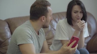 Kızgın adam portresi karısını evde onun sevgilisi mesajları ile onu cep telefonu gösteren bağırıyor. Erkek ve kadın arasındaki ilişkinin sorunları. İhanet, güvensizlik, ayrılık konsepti.