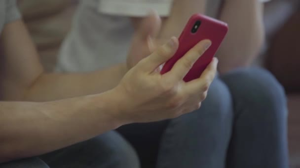 Homem irado não reconhecido gritando com sua namorada mostrando seu celular com mensagens de seu amante em casa. Problemas na relação entre homem e mulher. Traição, desconfiança, conceito de separação — Vídeo de Stock