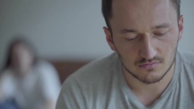 Ön planda ağlayan adamın portresi ve arka planda kanepede oturan öfkeli eşi bağırıyor. Erkek ve kadın arasındaki ilişkinin sorunları. İhanet, ayrılık konsepti