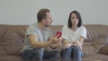 Kızgın adam portresi karısını evde onun sevgilisi mesajları ile onu cep telefonu gösteren bağırıyor. Erkek ve kadın arasındaki ilişkinin sorunları. İhanet, güvensizlik, ayrılık konsepti.