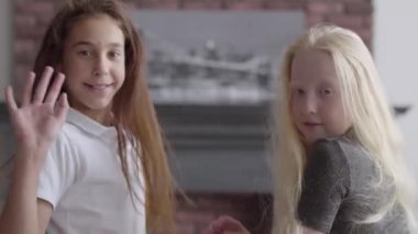 Esmer kız ve uzun saç sallayarak eller kamera gülümseyen bakıyor ile Albino kız portre. Dostluk kavramı. Carefree çocukluk. Gerçek insanlar serisi.