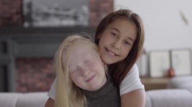 Portre sevimli küçük Albino kız kız arkadaşı gülümseyen kamera bakarak sarılmak. Dostluk kavramı. Carefree çocukluk. Gerçek insanlar serisi.