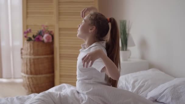Dítě kavkazské se zklidní nebo se probudí nebo se probudí, když se ráno po spánku osvěží na bílém lůžku v ložnici doma nebo v hotelu a na dovolené. Nový den. — Stock video