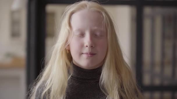 Porträt eines entzückenden Mädchens mit grauen Augen, das lächelnd in die Kamera blickt. ungewöhnliche Erscheinung. Unbeschwerte Kindheit. Gesicht einer blonden Kaukasierin mit langen Haaren. Serie "echte Menschen". — Stockvideo