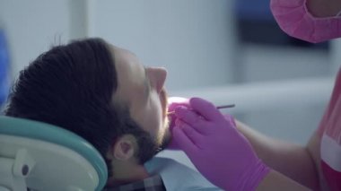 Diş hekimi tıbbi maske ve eldiven tıbbi aletler kullanarak hastanın dişlerini kontrol. Kadın profesyonel doktor stomatoloji uzmanı iş başında. Diş tedavisi, tıbbi konsept. Diş bakımı.