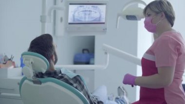 Diş hekimi tıbbi maske ve eldiven modern bir diş ofisinde tıbbi aletler kullanarak hastanın ağız kontrol. Kadın profesyonel doktor stomatoloji uzmanı iş başında. Diş tedavisi, tıbbi kavram.