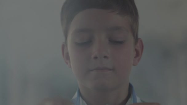 Retrato de primer plano del niño jugando con los fósforos en la habitación oscura y ahumada. El niño encendió el fósforo sonriendo. El chico juega con fuego. Incendios menores — Vídeo de stock