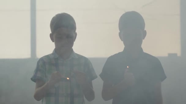 Hermanitos gemelos jugando con el fuego en la habitación humeante frente a una ventana. Niños sacando cerillas y cabezas más livianas y temblorosas. Los niños enseñan a no jugar con fuego. Concepto de peligro — Vídeos de Stock