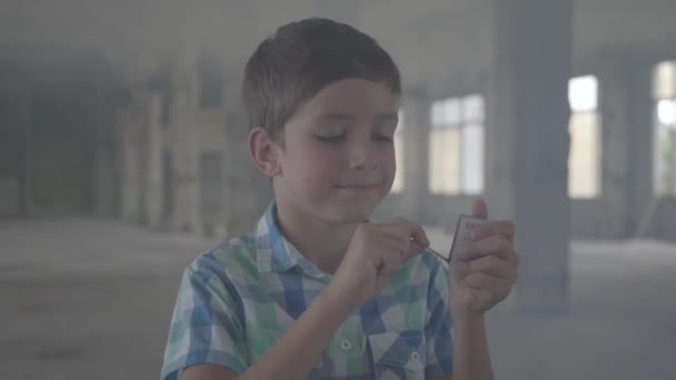Porträt eines niedlichen Jungen, der in einem verrauchten Raum ein Streichholz anzündet. — Stockvideo