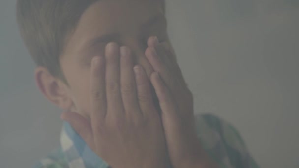 Close-up of confused scared boy standing in the smoky room coughing and covering face with his hands. Concept of danger. Fire, flammability, non-compliance with safety rules — Stock Video