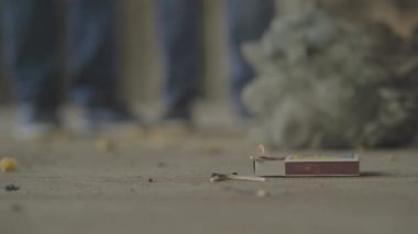 Yerde yanan kibrit kutusu, tanınmayan çocuklar kaçıyor. Yangın kavramı, yanıcılık, güvenlik kurallarına uyulmaması.