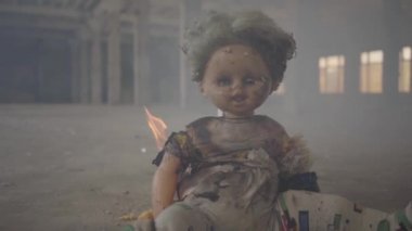 Terk edilmiş dumanlı bir binada yerde yanan korkunç bir bebek. Yangın kavramı, yanıcılık, güvenlik kurallarına uyulmaması.