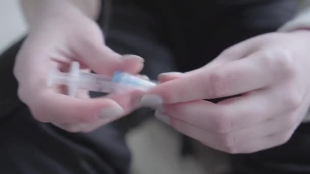 Vrouwelijke handen nemen een spuit uit de verpakking voorbereiding om de injectie close-up te maken. Verslaving aan drugs. Ongezonde levensstijl, slechte gewoonte. Drugsverslaafden. — Stockvideo
