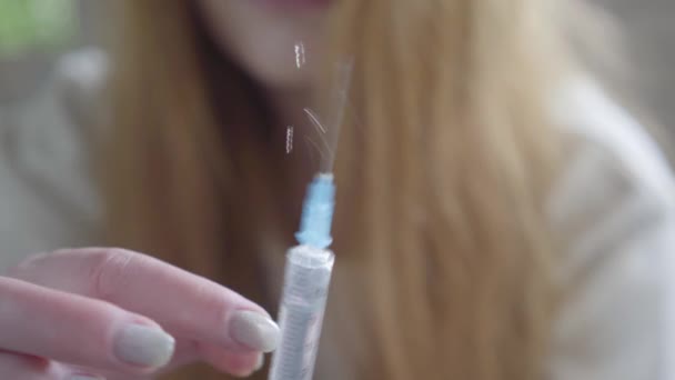 Female hands shake off heroin from a syringe preparing to make injection close up. Addiction to drugs. Unhealthy lifestyle, bad habit. Drug addicts — Stock Video