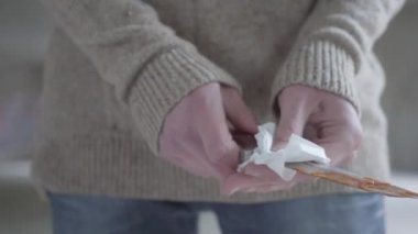 Elinde ketçap temizleyen genç adam, peçete yi kullanarak avcı bıçağının bıçağını yakından takip etti. Silahtaki kanın taklidi. Şiddet kavramı, cinayet.