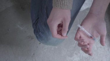 Bir doz daha ilaç aldıktan sonra titreyen şırıngalı genç kız. Yakından kapatın. Uyuşturucu bağımlıları.