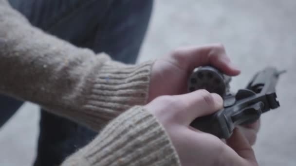 Des mains de jeune homme démontent et nettoient le gros plan de l'arme. Le gars qui se prépare à tuer des humains ou à se suicider — Video