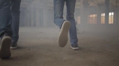Duman bulutu içinde terk edilmiş binada koşan iki çocuğun ayakları. Yerde yanan korkunç bir bebek. Yangın kavramı, yanıcılık, güvenlik kurallarına uyulmaması.