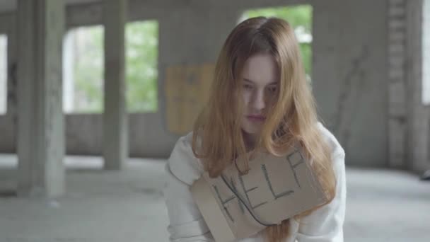 Retrato de una joven chica triste caucásica sentada en un edificio abandonado con drogas rompiendo o esperando apoyo y ayuda . — Vídeos de Stock