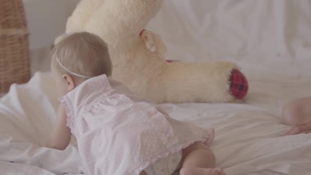 Kleine baby meisje spelen op het bed binnenshuis. Schattig kind thuis. Mooi kind met moeder. Plezier. Slow Motion. — Stockvideo