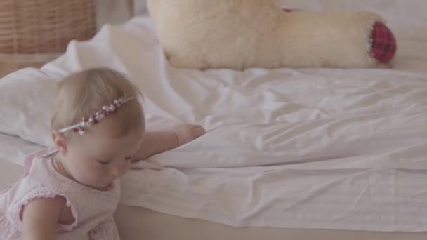 Liten baby flicka som leker på sängen inomhus. Söta barn hemma. Vackert barn med mamma. Ha kul. Slow motion. — Stockvideo