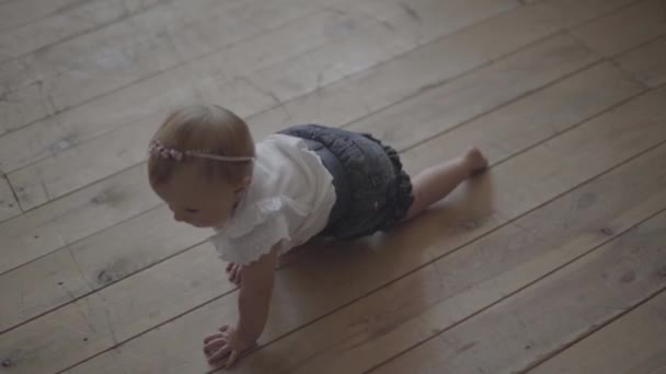 Schattige baby meisje verkenningen op de vloer van het huis. Kid thuis spelen. Schattig gelukkig kind binnenshuis. Slow Motion — Stockvideo