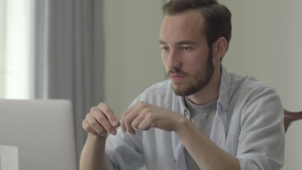 Retrato de homem bonito jovem quebrando lápis com raiva sentado na frente de seu computador no escritório. Problemas no trabalho, dificuldades, emoções. Série de pessoas reais . — Vídeo de Stock