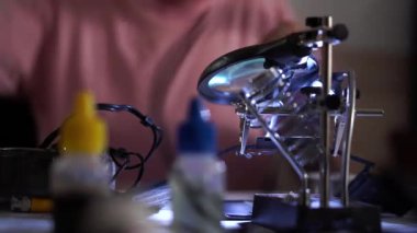 Usta adam iş yerinde lehim demir ile işini bitiriyor ve uzaklaşıyor. Meslek kavramı, doğru çalışma, mühendis pozisyonu