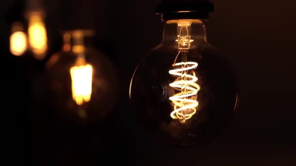 검은 배경 위에 두 개의 텅스텐 전구 램프. 현대 가정에서 빛과 어둠, 아이디어, 전기의 개념. — 비디오
