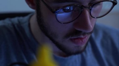 İş yerinde lehimdemirle çalışan gözlüklü başarılı genç sakallı adamın portresi. Meslek kavramı, doğru çalışma, mühendis pozisyonu