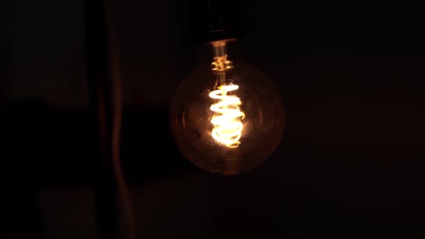 Volfram glödlampa lampa över svart bakgrund. Koncept av ljus och mörker, idé, elektricitet i modernt hem. — Stockvideo