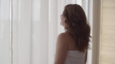 Lüks daire ev ya da modern bir otel de lüks daire ev veya modern otel esenlik zevk pencereden bakarak duran perde dantel açılış zengin olgun kadın arka görünümü. Mutlu beyaz kadın yeni günü selamlıyor.