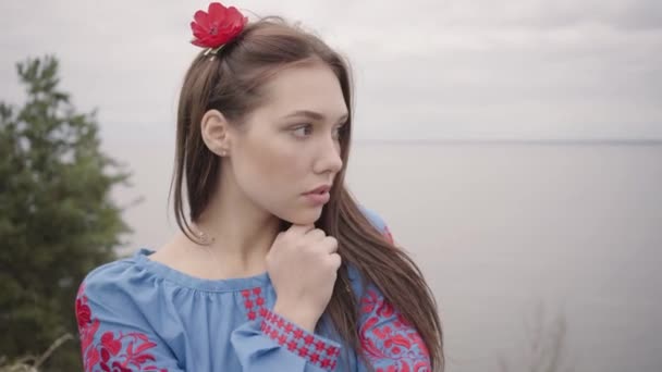 Linda chica independiente que usa vestido de moda de verano largo que mira con confianza en la cámara disfrutando de los puestos en el fondo del lago. Ocio de una hermosa joven al aire libre. Serie de personas reales . — Vídeo de stock