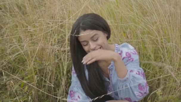 Retrato lindo seguro de sí mismo despreocupado chica afroamericana con vestido de moda de verano largo disfrutando sentado en el campo. Ocio y fin de semana de una bonita joven al aire libre. Serie de personas reales . — Vídeo de stock